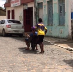 Um menino empurrando o outro no carrinho 